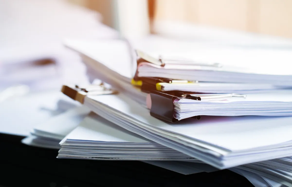 Photo d'une calculatrice, lunettes et stylo sur des documents financiers.